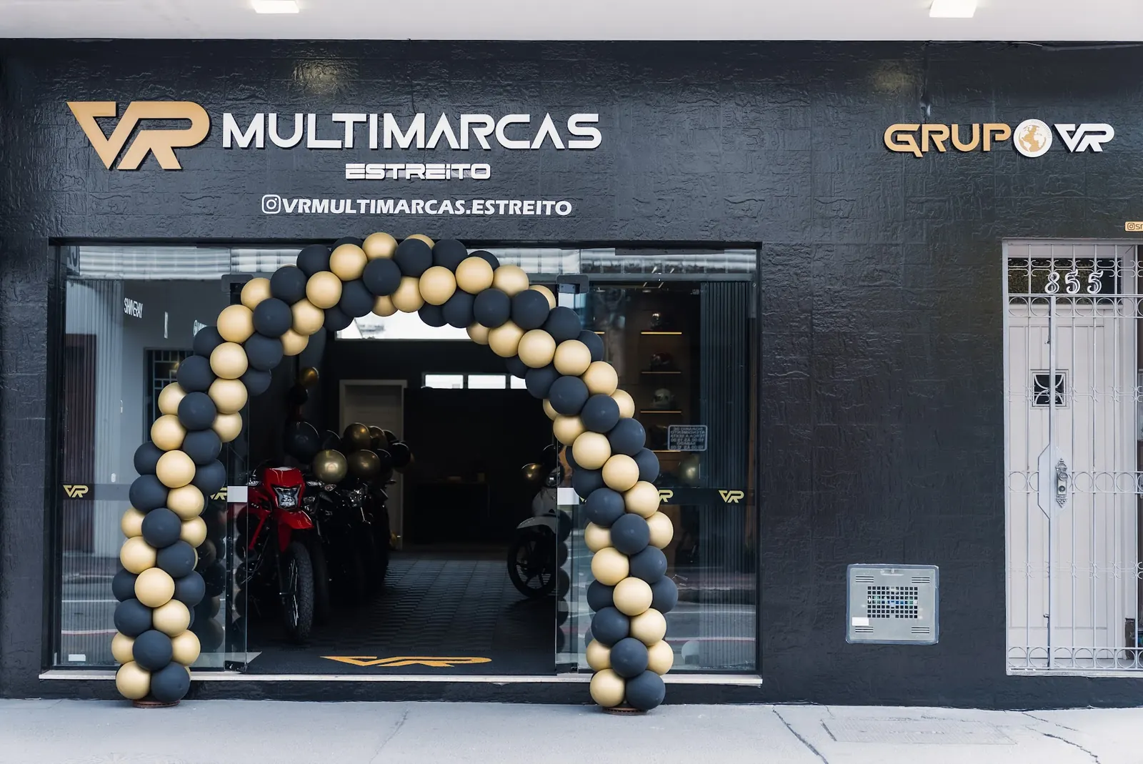 Fachada da VR Multimarcas Estreito, em Florianópolis, com arco de balões pretos e dourados na inauguração
